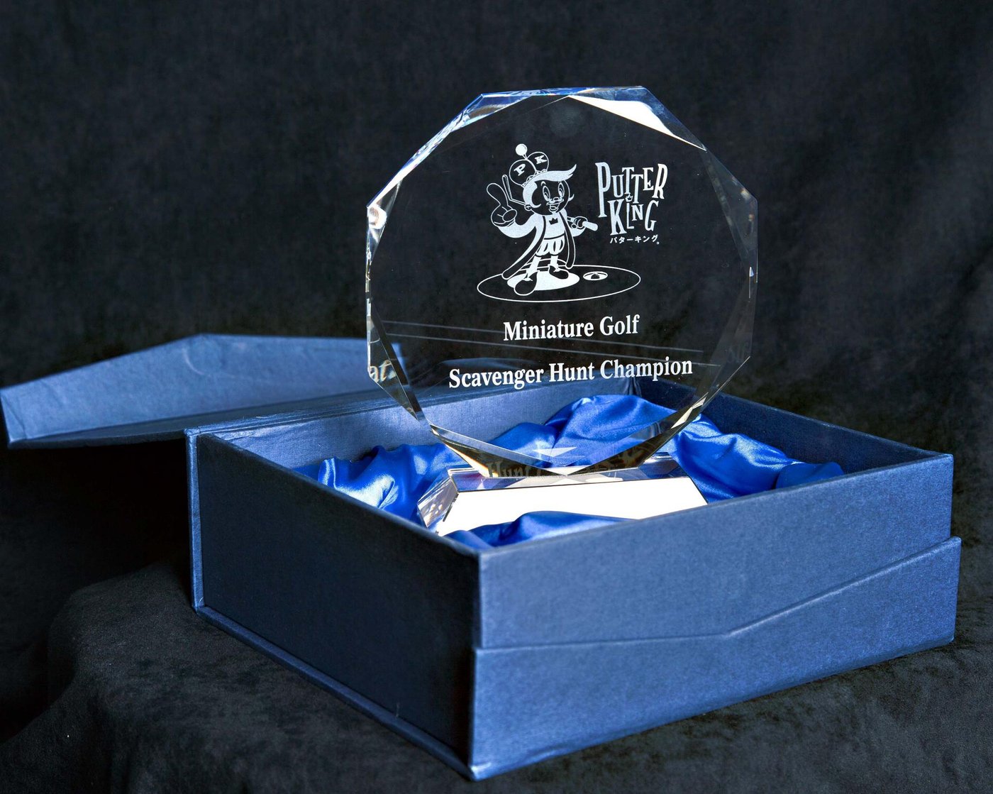 The 2011 Putter King Miniature Golf Scavenger Hunt Champion crystal trophy in its blue presentation box, engraved with the Putty mascot and the Putter King wordmark